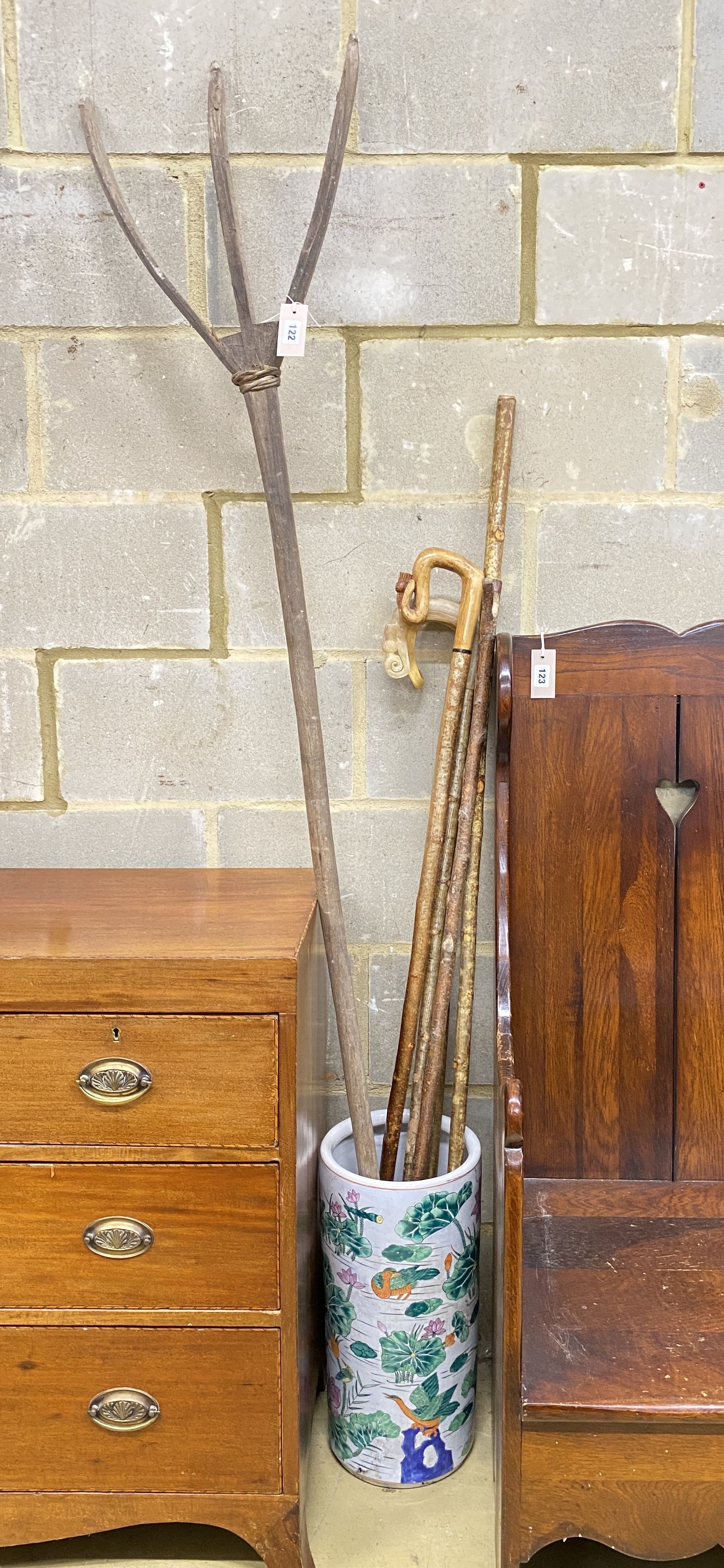 Four assorted walking sticks and canes, a primitive wood rake and a Chinese stick stand